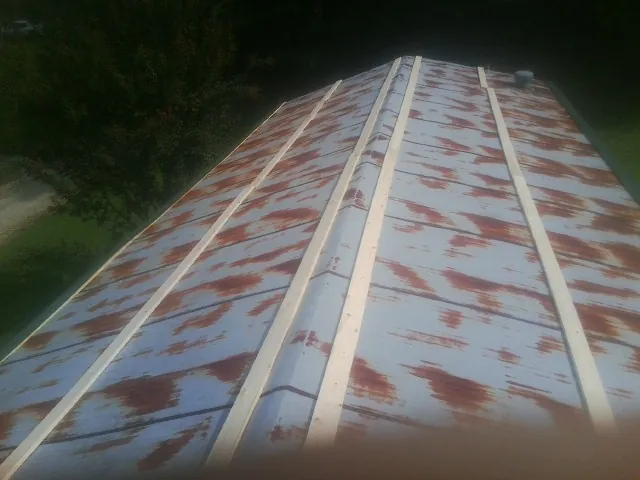 Rusted metal roof panels with new wood purlins before replacement — Storm Damage Roof Repair in Flat Rock by Roofing Brothers