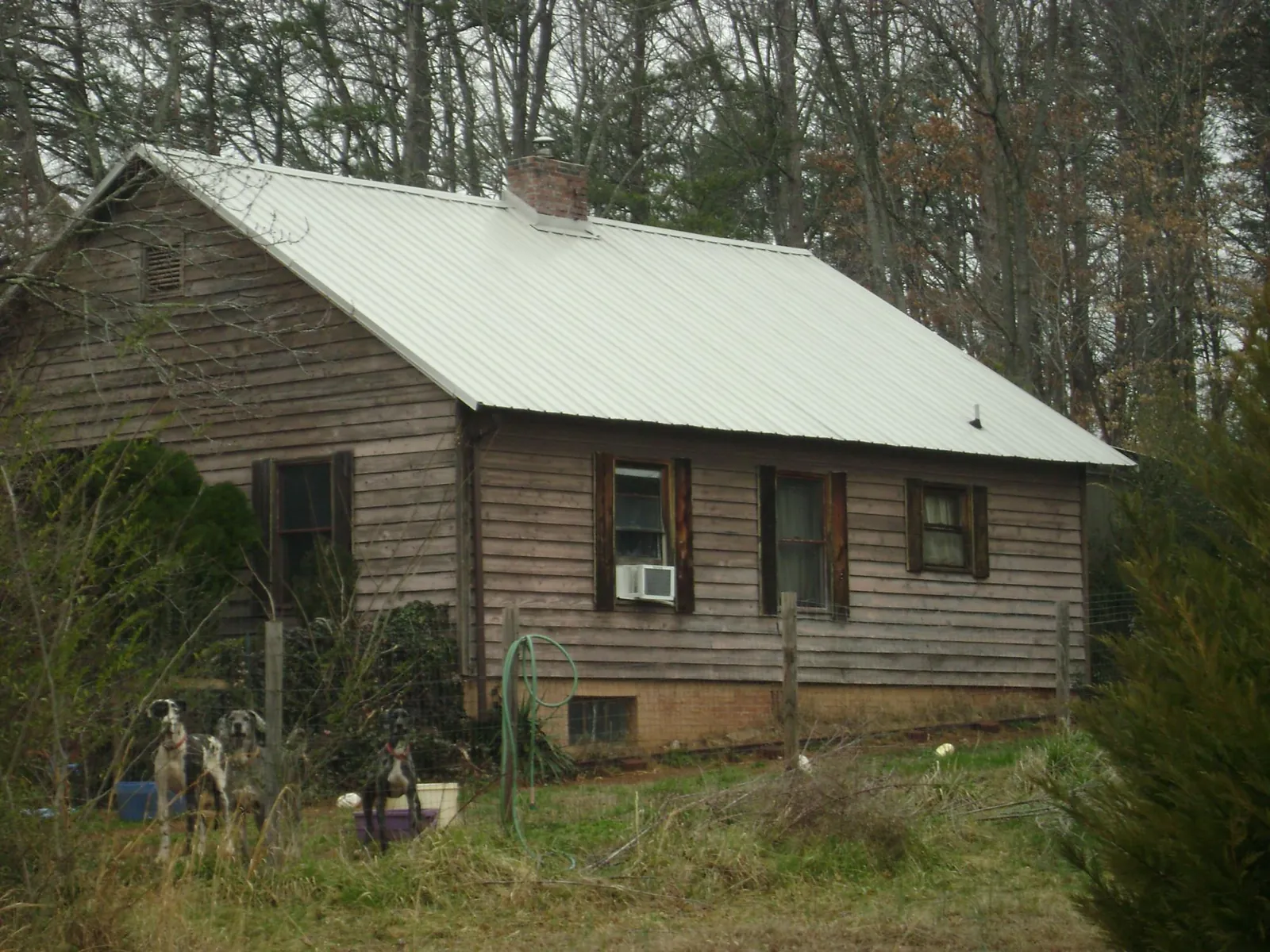 White metal roof on an old wood sided farmhouse, from a Metal Roof Installation job in Flat Rock